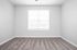 Bright and inviting bedroom featuring plush carpeting, a large window with blinds, and soft neutral walls.