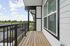 Bright and inviting balcony with modern railing overlooking lush greenery, offering a serene outdoor escape.