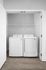 Modern laundry area featuring a sleek washer and dryer with ample shelving, perfect for a convenient and stylish home.