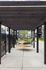 Charming outdoor space featuring hammocks under a stylish wooden pergola, ideal for relaxation in a modern apartment complex courtyard.