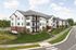 Elegant modern apartment complex with three stories, featuring stylish architecture and surrounded by lush greenery.