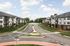 Charming apartment complex with modern design, surrounded by lush greenery and a peaceful street view.