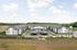 Elegant apartment complex with modern architecture, expansive parking, and lush green surroundings&mdash;perfect for serene living.