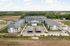 Stunning aerial view of a modern apartment complex with expansive green surroundings, ample parking, and community amenities.