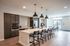 Modern apartment kitchen featuring sleek cabinetry, large island with seating, and stylish pendant lighting, ideal for entertaining.
