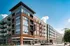 Modern urban apartment building with contemporary design, featuring large windows and private balconies, ideal for city living.