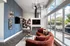Chic living room with sleek contemporary design, featuring a vibrant red sofa, stylish wall art, and a cozy fireplace under a modern chandelier.