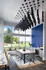 Modern dining area with striking pendant lighting and panoramic windows offering scenic views, featuring a sleek wooden table surrounded by stylish grey chairs.
