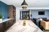 Elegant open-concept living area featuring a sleek modern kitchen, stylish pendant lighting, and cozy lounge with a wall-mounted TV.