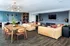 Contemporary apartment living area with cozy leather sofas, stylish wooden dining table, and modern kitchen featuring elegant blue tile backsplash.
