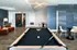 Chic communal area featuring a sleek billiards table, modern seating, and contemporary lighting.