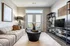 Sleek modern living room with cozy beige sofa, stylish black coffee table, and elegant floor lamp. Bright natural light streams through French doors, accentuating the chic design.