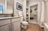 Modern bathroom with sleek granite countertop, polished wood flooring, and spacious walk-in closet for organized living.