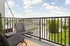 Charming balcony with stylish wicker chairs offering a panoramic view of the cityscape and lush greenery, perfect for relaxing.