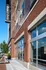 Contemporary apartment building exterior with stylish red brick facade and large glass windows featuring Whiskey River sign.