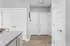 Bright and inviting hallway with modern white paneled doors and stylish granite countertop, showcasing a contemporary apartment design.