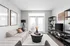 Modern living room with plush beige sofa, sleek black shelving, and elegant decor, featuring abundant natural light through stylish French doors.