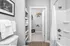 Bright and modern bathroom with sleek shower, elegant shelving, and spacious walk-in closet for optimal storage.