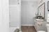 Sleek modern bathroom with a stylish granite countertop, spacious vanity, and elegant glass light fixtures.
