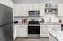 Modern kitchen with sleek stainless steel appliances, granite countertops, and elegant white cabinetry.