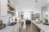 Contemporary open-concept kitchen and living space with sleek granite countertops, modern cabinetry, and cozy seating area. Abundant natural light enhances the stylish decor.
