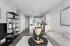 Contemporary apartment living area with sleek open kitchen, stylish shelving, and cozy lounge space featuring chic decor.