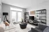 Contemporary living room with natural light, cozy sofa, modern decor, and elegant shelving unit, perfect for stylish living.
