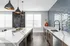 Modern kitchen with sleek pendant lighting, elegant granite countertops, and textured blue backsplash offering a luxurious and contemporary design.