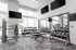 Modern fitness center with sleek equipment, featuring free weights, cardio machines, and ample natural light from large windows.