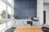 Modern kitchen nook featuring sleek cabinetry, vibrant blue accent wall, and ample natural light.