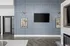 Sophisticated living area with elegant wall paneling, modern light fixtures, and a sleek flat-screen TV above a stylish fireplace.