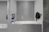 Modern gray-tiled wash area equipped with convenient wall-mounted hoses and stylish dispensers, embodying sleek functionality.