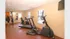 Inviting fitness room with state-of-the-art exercise equipment, including a treadmill and elliptical, providing a perfect workout environment bathed in natural light.