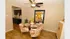 Chic dining area with stylish patterned chairs, a glass table set for four, and a warm, inviting ambiance near the modern kitchen.
