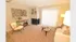 Bright and cozy living room with plush carpeting, modern decor, and ample natural light streaming through large sliding doors.