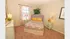 Cozy bedroom with colorful bedding, elegant lamps, and tasteful decor, featuring natural light from the window and a touch of greenery.