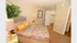 Inviting bedroom with vibrant bedding, cozy carpet, and abundant natural light, featuring stylish decor and a spacious walk-in closet.