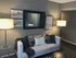 Cozy living room with elegant gray walls, a plush white sofa adorned with stylish cushions, complemented by warm lighting and inspirational wall art.