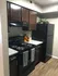 Modern kitchen with sleek dark cabinetry, elegant granite countertops, and stylish appliances.