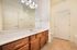 Elegant bathroom with stunning wooden cabinetry, spacious countertop, and modern lighting.