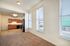 Bright and inviting open-concept living space with large windows, adjacent to a spacious kitchen featuring modern appliances and elegant cabinetry.
