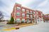 Charming redbrick apartment building with elegant balconies, modern windows, and inviting outdoor space. Ideal urban living environment.
