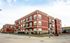 Charming red brick apartment building with spacious balconies and modern design in a serene neighborhood.