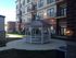Charming apartment complex with elegant balconies and a picturesque gazebo in a landscaped courtyard.