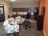 Modern open-concept lounge area with colorful seating, sleek kitchen appliances, and a stylish dining nook.