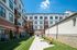Vibrant apartment complex featuring modern architecture, spacious balconies, and a picturesque courtyard with inviting benches.