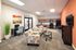Inviting living space with modern decor, featuring stylish patterned seating, a sleek kitchen with wood cabinetry, and a cozy workspace.