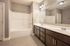 Elegant bathroom featuring a dual-sink vanity, sleek finishes, and a spacious bathtub for modern living.