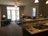 Cozy apartment living room with plush seating and ambient lighting, connected to a modern kitchen with a sleek granite countertop and double sink.