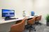 Modern workspace featuring dual computer stations, stylish leather chairs, and chic decor for a productive environment.